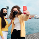 Young women with face mask taking selfies with a mobile phone outdoors. - PhotoDune Item for Sale