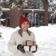 Caucasian woman holding Christmas present  in front of house - PhotoDune Item for Sale