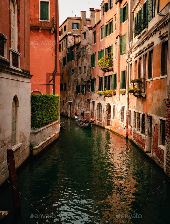 Characteristic canal of Venice with gondolier while sailing - Stock Photo - Images