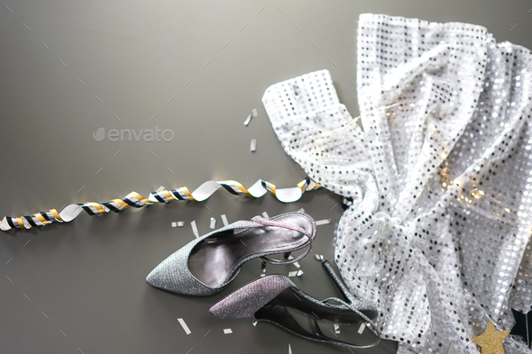 Formal evening wear silver high heels and glittery dress laying on the grey background. - Stock Photo - Images