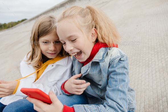 Preteen friends boy and girl play smartphone gadget. Stock Photo by ...