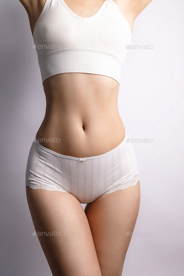 Tanned woman in great shape, perfect body shape. Parts of a female body in  underwear, studio shot. Stock Photo by nikolast1
