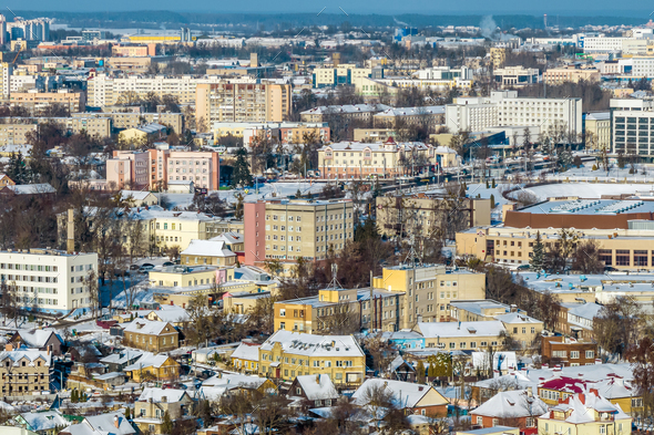 panoramic aerial view of a winter city with a private sector and high-rise residential areas snow
