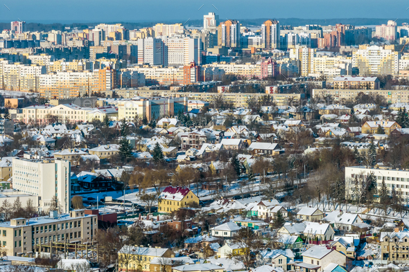 panoramic aerial view of a winter city with a private sector and high-rise residential areas