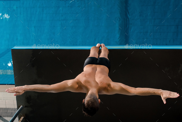 top view of swimmer standing with outstretched hands near swimming pool