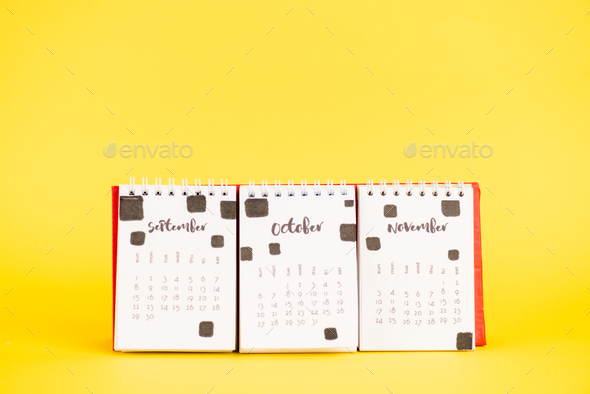 Paper calendar with september, october and november months on yellow ...