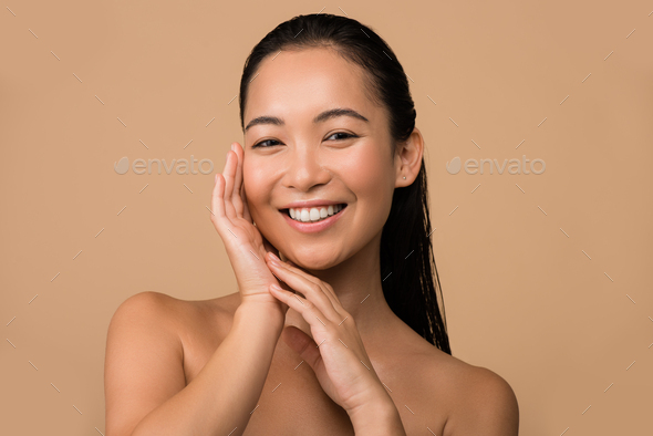 Asian Beautiful Face Nude - smiling beautiful naked asian girl touching face isolated on beige Stock  Photo by LightFieldStudios