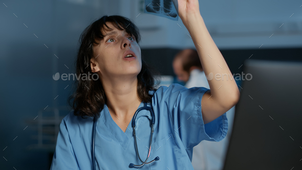 Assistant analyzing patient lungs radiography typing medical expertise on computer - Stock Photo - Images