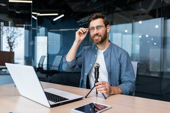 Portrait of successful man inside office, businessman with professional microphone recording online - Stock Photo - Images