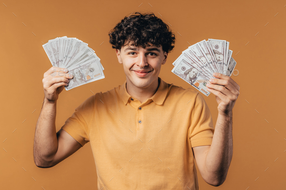 Rich excited man with cash money - USD currency dollars banknotes on yellow wall.  - Stock Photo - Images