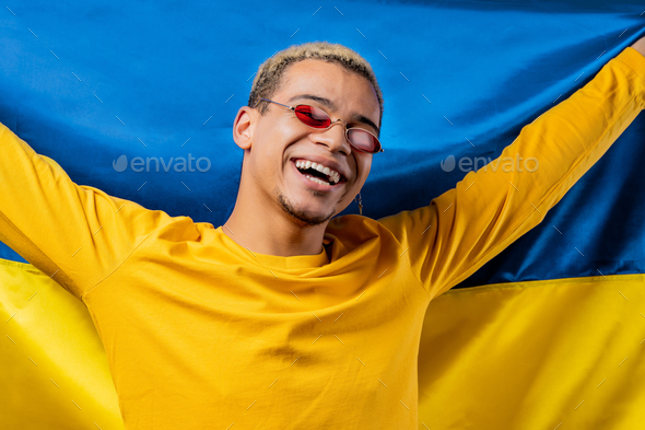 Smiling man with national Ukrainian flag. Ukraine, patriot, victory in war celebration, banner - Stock Photo - Images