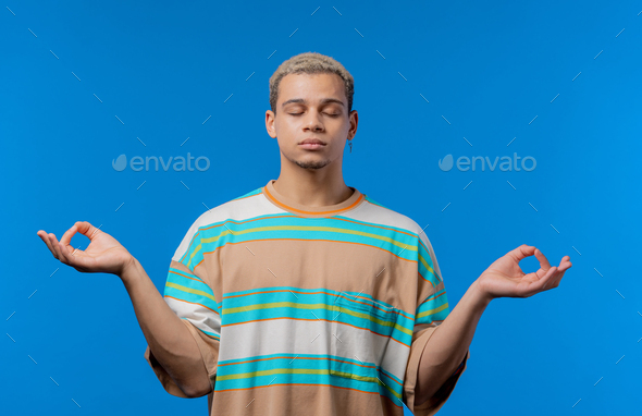 Calm man relaxing, meditating, refuses stress. Curly haired guy breathes deeply, calms down blue - Stock Photo - Images