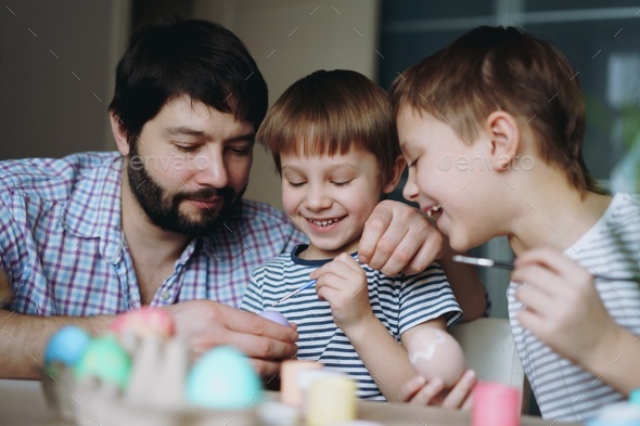 father and kids painting eggs for easter - Stock Photo - Images