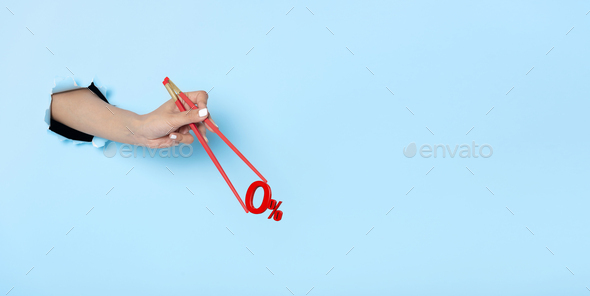 Woman hand holding chopsticks showing 0% number or zero percent isolated on blue banner background - Stock Photo - Images