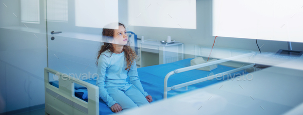 Little sick girl sitting alone in hospital ward. - Stock Photo - Images