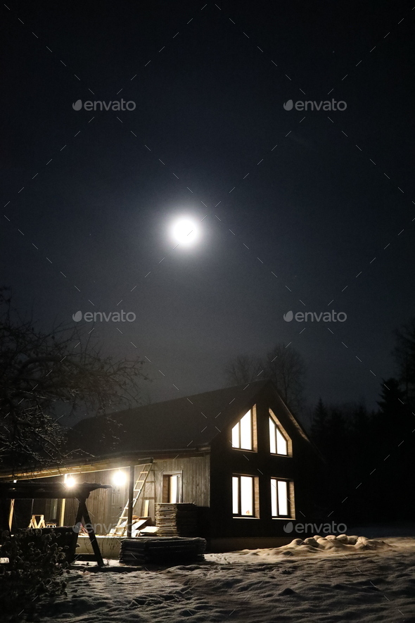 Landscape with house at night under dark sky with full moon. Spooky landscape with house in night.