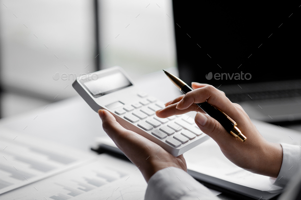 Businessman is using a calculator to calculate. - Stock Photo - Images