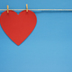 Red heart hanging on string with small clothes pins on blue background  Stock Photo by IrynaTolm