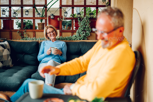 Senior couple drinking coffee or tea at balcony or terrace at home - Stock Photo - Images