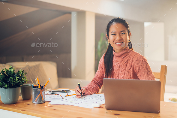 Portrait of a Vietnamese Asian woman using a laptop at home - Stock Photo - Images
