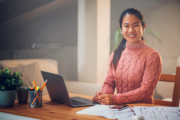 Portrait of a Vietnamese Asian woman using a laptop at home - Stock Photo - Images