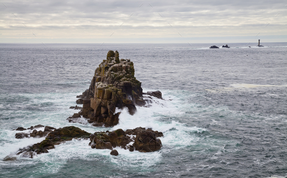 Land's End, rock islets offshore, the Penwith peninsula, view to a lighthouse and out to sea. - Stock Photo - Images
