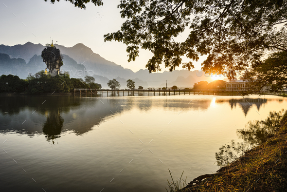 Sunrise over the lake at Hpa An, a footbridge, shrine and mountain landscape. - Stock Photo - Images
