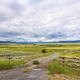 The Montana landscape, open grassland, fences, dirt road, and clouds. - PhotoDune Item for Sale
