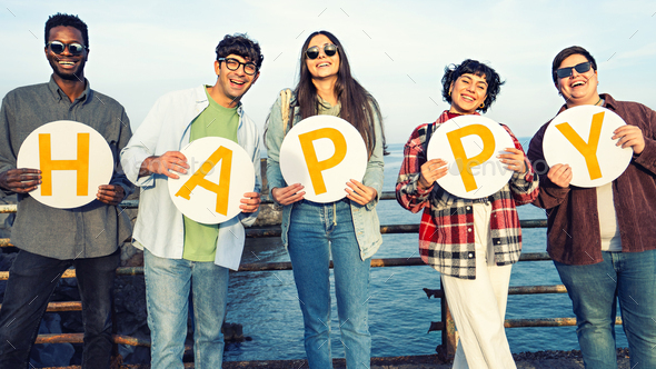 Young people holding discs with the word "happy" - Stock Photo - Images