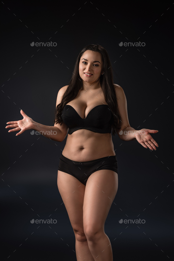 Smiling plus size girl in underwear with hands on background Stock Photo by LightFieldStudios
