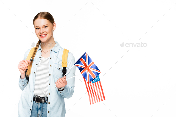 happy girl with braid and backpack holding flags of america and united kingdom isolated on white