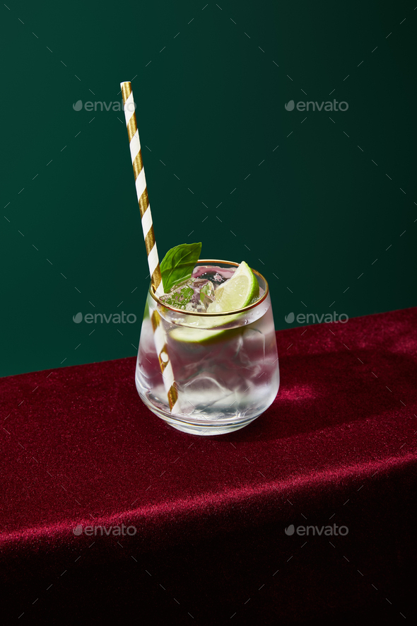 high angle view of old fashioned glass with golden rim with mojito and striped drinking straw - Stock Photo - Images