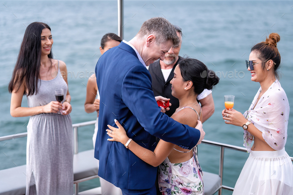 Business man and girl friend on holiday sailing on the yacht proposed marry