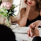 selective focus of man and woman holding hands while sitting at served table in plane - PhotoDune Item for Sale