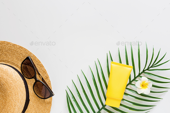 Top view of suncream, straw hat, palm leaf, sunglasses. spf cream on white background with copy - Stock Photo - Images