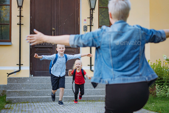 Mother meets children from school. Caucasian boy and girl running towards mom hugging her. - Stock Photo - Images