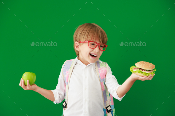 Happy child student against green chalkboard - Stock Photo - Images