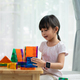 A 5 years old asian little girl is pay attention to build the house toys from the magnetic blocks. - PhotoDune Item for Sale