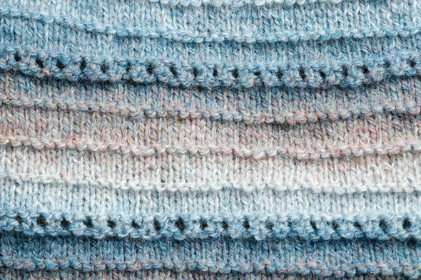 Knitted background. Knitted fabric texture, pure sheep wool, color gradient.