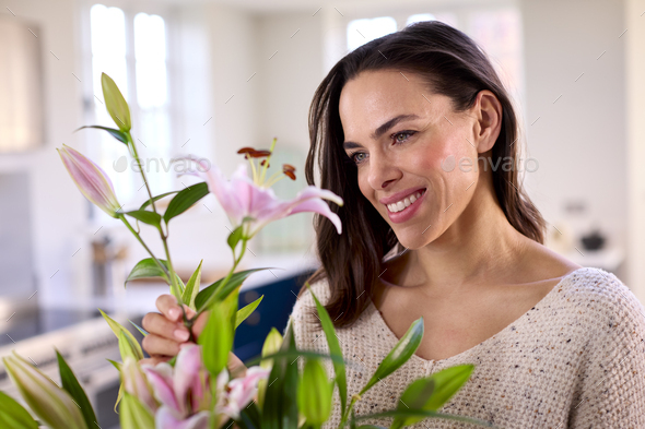 Smiling Woman At Home Arranging Bouquet Of Flowers In Glass Vase - Stock Photo - Images