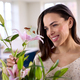 Smiling Woman At Home Arranging Bouquet Of Flowers In Glass Vase - PhotoDune Item for Sale