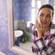Woman At Home Wearing Pyjamas Looking In Bathroom Mirror Taking Off Make Up With Wipe - PhotoDune Item for Sale