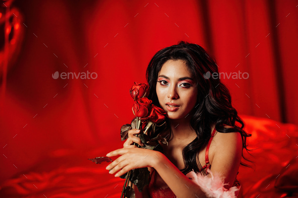 Portrait of smile sexy asian girl glam makeup in lingerie with red roses and coupe glass champagne - Stock Photo - Images
