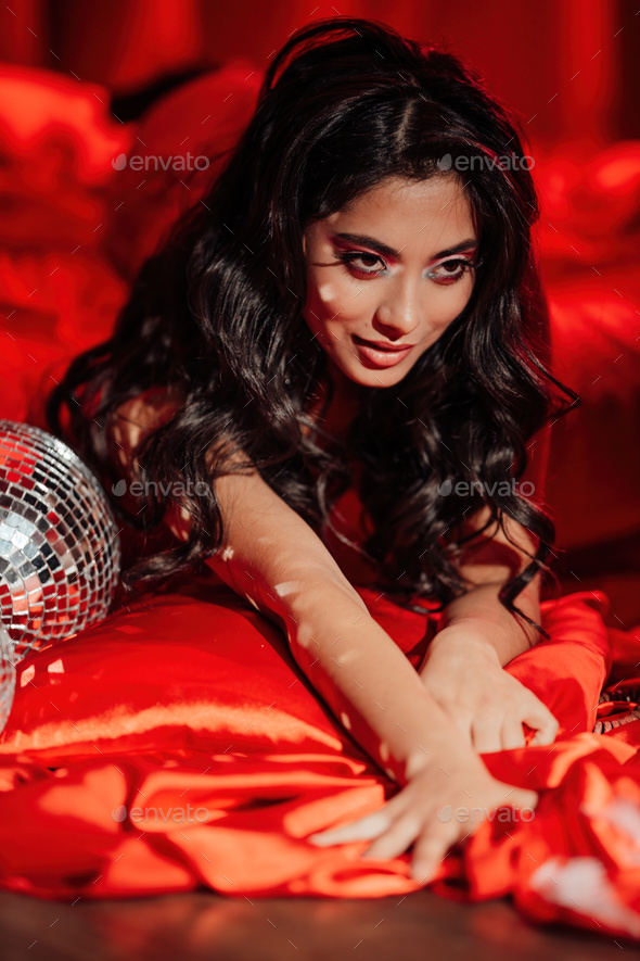 Portrait of smile sexy asian girl glam makeup in red lace lingerie lying on bed at valentines day - Stock Photo - Images