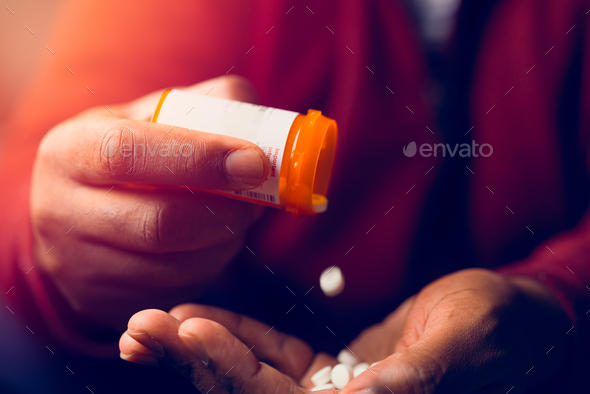 close up of man at home sitting down handling prescription pill bottle - Stock Photo - Images