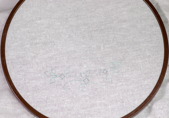 Wooden Embroidery hoop with a clean white piece of linen cloth and a simple design.