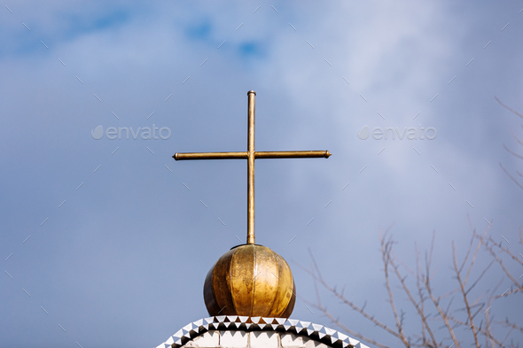 Orthodox church cross on a background of blue sky with clouds. Easter. Christmas. Place for text.