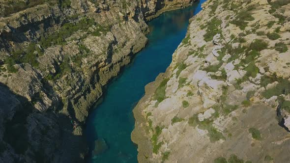 Arial shot of  Wied Il-Ghasri, a secluded inlet with a tiny pebbly beach wedged between high cliffs alt