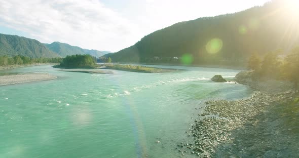 Low Altitude Flight Over Fresh Fast Mountain River with Rocks at Sunny Summer Morning. alt