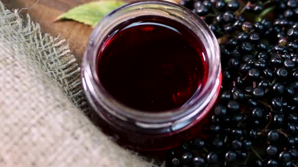 Elderberry Juice In A Glass Jar. Black Elderberry On A Wooden Background. Herbal Medicine